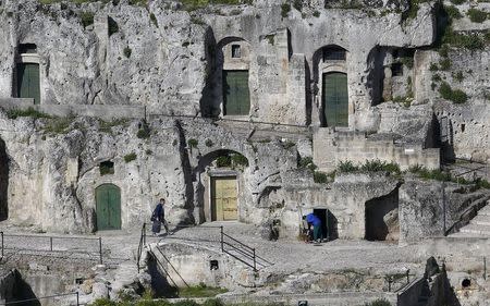Men are seen outside Matera's Sassi limestone cave dwellings in southern Italy April 30, 2015. REUTERS/Tony Gentile