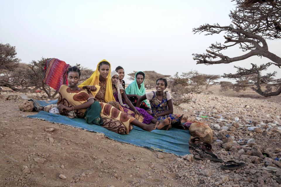In this July 15, 2019 photo, Ethiopian Tigray teen migrants rest under a tree on the last stop of their journey before leaving by boat to Yemen in the evening, in Obock, Djibouti. An increasing number of the travelers include women and girls, who face rape and torture at the hands of human traffickers. (AP Photo/Nariman El-Mofty)