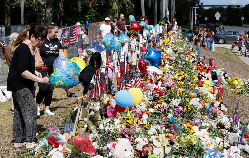 FILE PHOTO: Visitors view memorials at Marjory Stoneman Douglas High School in Parkland