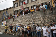 People wearing face masks wait for the riders to pass during the first stage of the Tour de France cycling race over 156 kilometers (97 miles) with start and finish in Nice, southern France, Saturday, Aug. 29, 2020. (AP Photo/Christophe Ena)