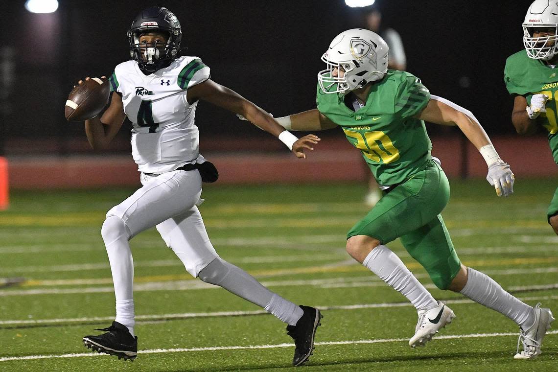 Leesville Road quarterback Deiondre Goldston (4) looks to pass against pressure from Cardinal Gibbons’ Griffin Cockerham (30) during the first half. The Cardinal Gibbons Crusaders and the Leesville Road Pride met in a conference football game in Raleigh, N.C. on October 27, 2023.