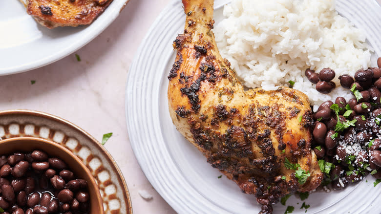 Cooked mojo chicken on plate with rice and beans 