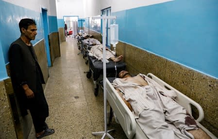 Injured men receive treatment in the hospital after sustaining wounds from a blast at a wedding hall in Kabul, Afghanistan