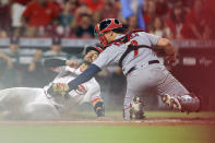 Cincinnati Reds' Eugenio Suarez, left, is out at home plate as St. Louis Cardinals' Andrew Knizner, right, tags him during the seventh inning of a baseball game in Cincinnati, Friday, July 23, 2021. (AP Photo/Aaron Doster)