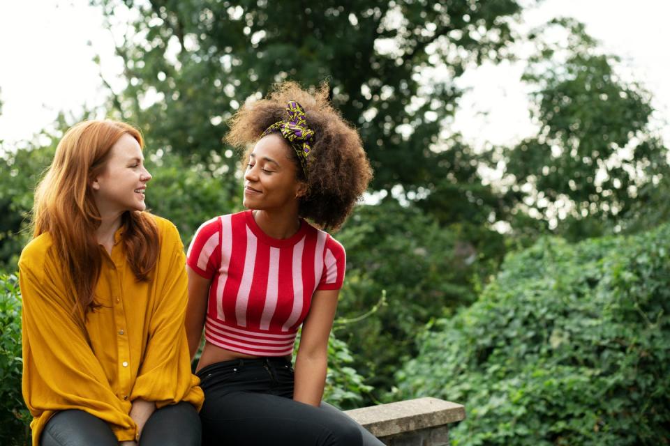 a couple of women sitting on a bench