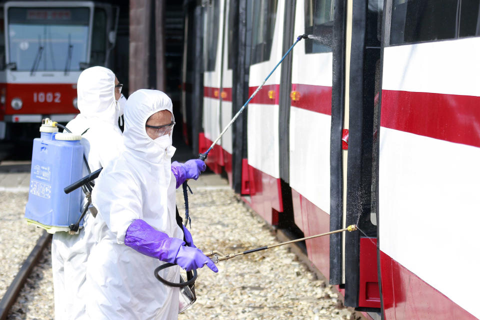 FILE - In this Feb. 26, 2020, file photo, Members from an emergency anti-epidemic headquarters in Mangyongdae District, disinfect a tramcar of Songsan Tram Station to prevent new coronavirus infection in Pyongyang, North Korea. As a new and frightening virus closes in around it, North Korea presents itself as a fortress, tightening its borders as cadres of health officials stage a monumental disinfection and monitoring program. (AP Photo/Jon Chol Jin, File)