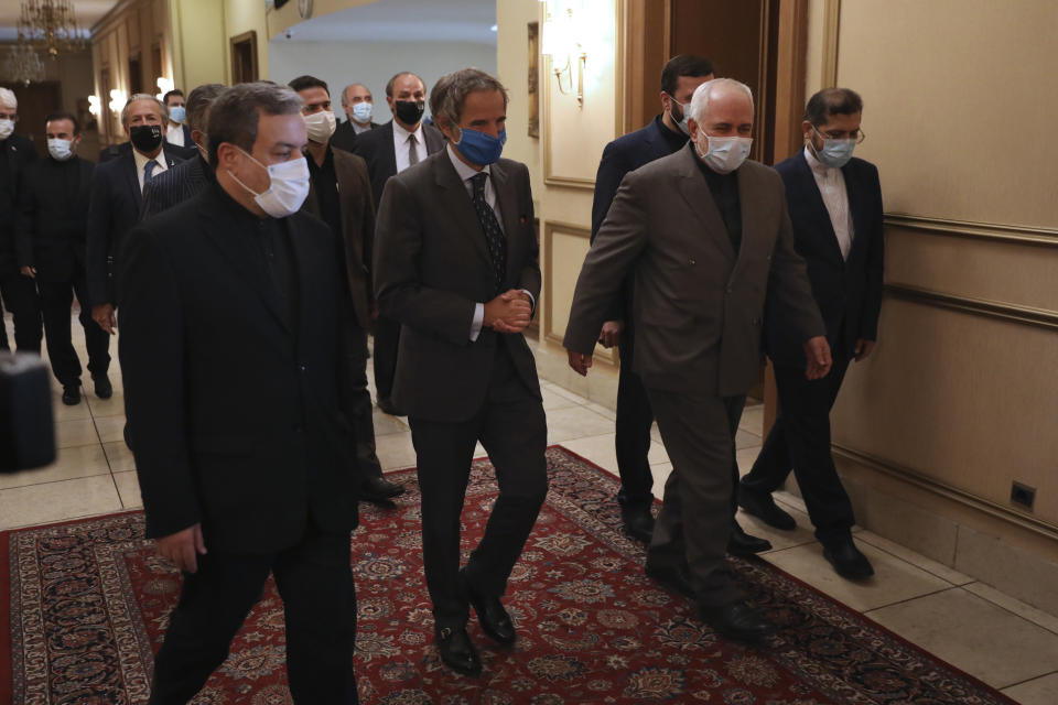 Director General of International Atomic Energy Agency, IAEA, Rafael Mariano Grossi, center, is welcomed by Iran's Foreign Minister Mohammad Javad Zarif, center right, for a meeting in Tehran, Iran, Tuesday, Aug. 25, 2020. Grossi arrived in Iran on Monday to press for access to sites where authorities are thought to have stored or used undeclared nuclear material. (AP Photo/Vahid Salemi)