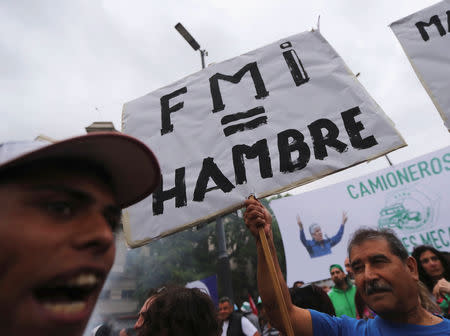 A man holds a sign that reads “IMF (International Monetary Fund) = Hunger" during a protest against a cost increase in public and utility services in Buenos Aires, Argentina, January 10, 2019. REUTERS/Marcos Brindicci