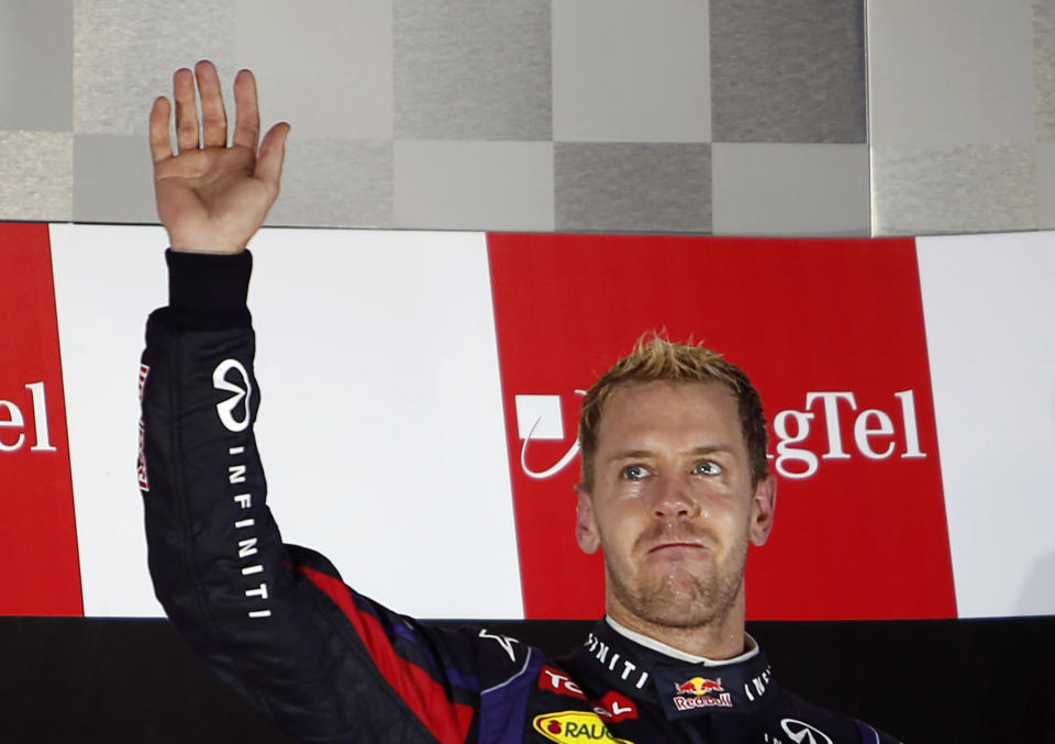Red Bull Formula One driver Sebastian Vettel of Germany waves on the podium after winning the Singapore F1 Grand Prix at the Marina Bay street circuit in Singapore September 22, 2013. REUTERS/Tim Chong (SINGAPORE - Tags: SPORT MOTORSPORT F1)