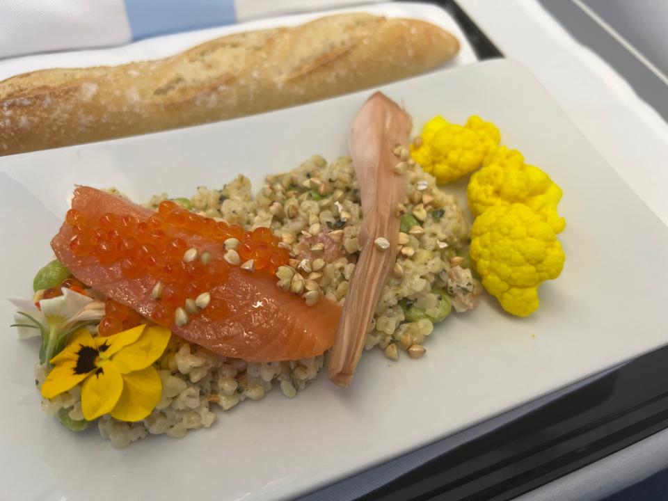 A tray of truffle-topped scallops served with a bread roll that the author ate on a La Compagnie flight.