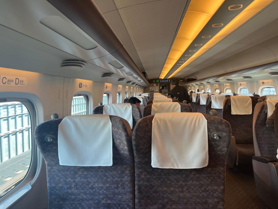The inside of the bullet train facing towards the back of the car.