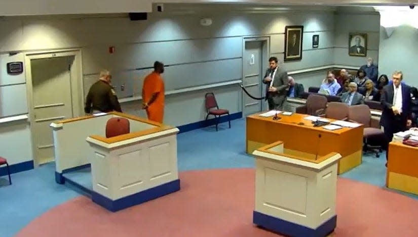 Defendant Kaiyell Sanders, dressed in an orange prison jumsuit, walks to the defense table for his hearings Wednesday, March 22, 2023 at the Dinwiddie (Va.) Courthouse. Sanders, a sergeant with the Henrico County sheriff's office, is one of 10 people charged in the March 6 death of Irvo Otieno at Central State Hospital