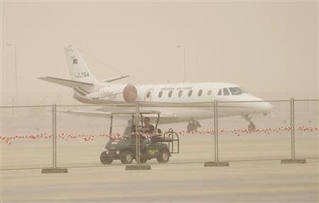 An aircraft is pictured during a sandstorm at the Dubai Airshow November 17, 2013. REUTERS/Ahmed Jadallah
