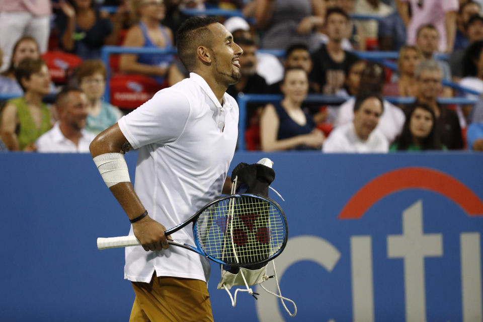 Nick Kyrgios, left, of Australia, carries a bag containing a pair of shoes to Stefanos Tsitsipas, of Greece, during a break in play in a semifinal at the Citi Open tennis tournament, Saturday, Aug. 3, 2019, in Washington. (AP Photo/Patrick Semansky)