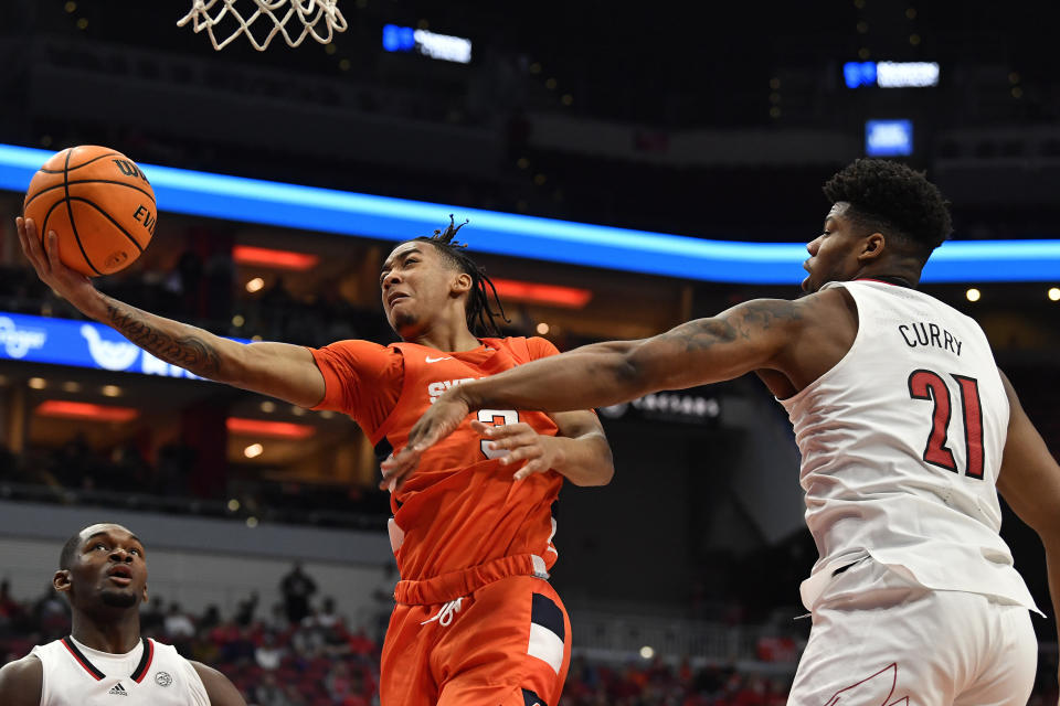 Syracuse guard Judah Mintz (3) attempts a layup past Louisville forward Sydney Curry (21) during the first half of an NCAA college basketball game in Louisville, Ky., Tuesday, Jan. 3, 2023. (AP Photo/Timothy D. Easley)