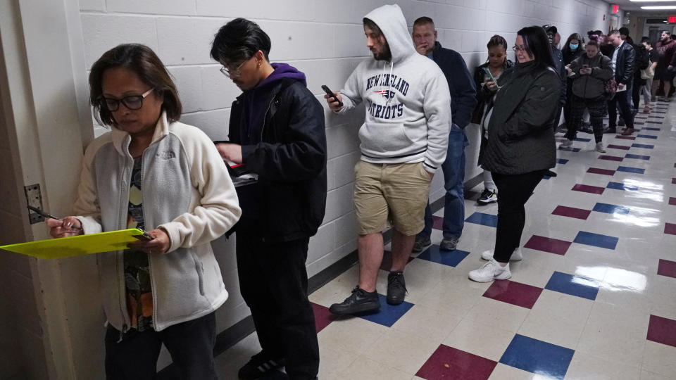 People wait in line to register before voting at the St. Anthony Community Center, Tuesday evening, Nov. 8, 2022, in Manchester, N.H. (AP Photo/Charles Krupa)