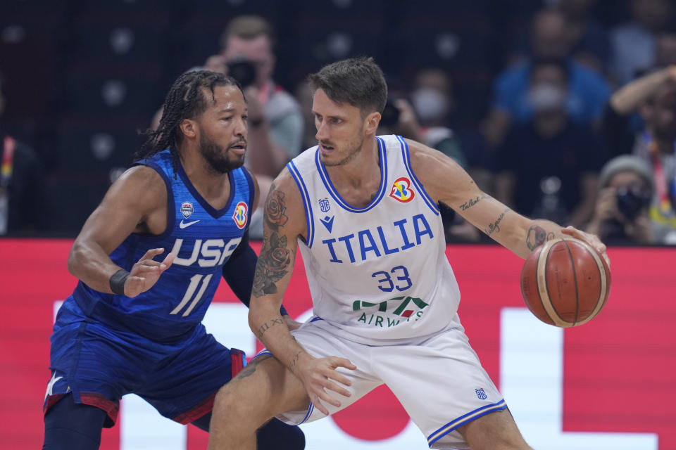 Italy forward Achille Polonara (33) dribbles against U.S. guard Jalen Brunson (11) during the Basketball World Cup quarterfinal game between Italy and U.S. at the Mall of Asia Arena in Manila, Philippines, Tuesday Sept. 5, 2023. (AP Photo/Michael Conroy)