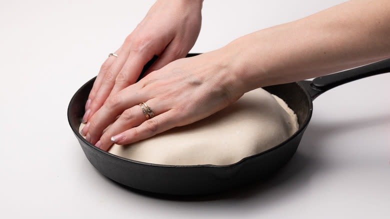 tucking pastry around pan contents