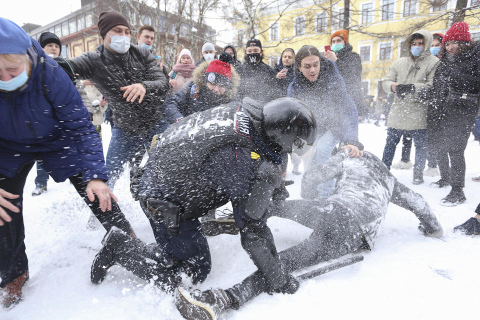 Un policía detiene a un hombre mientras otros manifestantes intentan ayudarle durante una protesta el domingo 31 de enero de 2021 contra el encarcelamiento del opositor Alexei Navalny, en San Petersburgo, Rusia. (AP Foto/Valentin Egorshin)