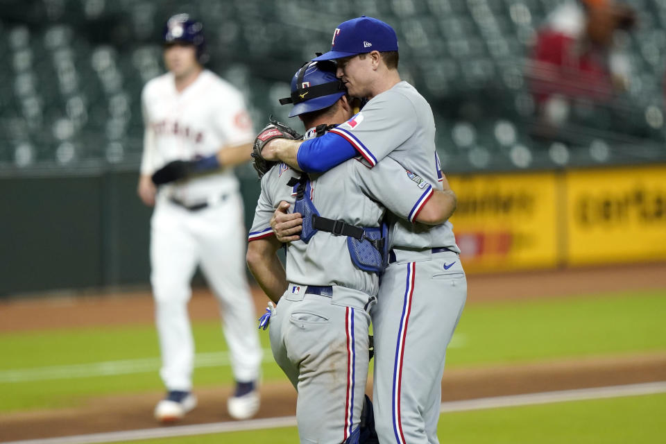 Texas Rangers starting pitcher Kyle Gibson, right, hugs catcher Jeff Mathis after a baseball game against the Houston Astros Wednesday, Sept. 16, 2020, in Houston. The Rangers won 1-0. (AP Photo/David J. Phillip)