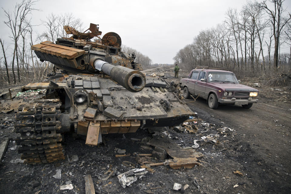 FILE - A car passes a destroyed tank abandoned on the road at a former Ukrainian army checkpoint that was overran last month by Russia-backed separatists during the offensive for Debaltseve, outside the city of Chornukhyne, Ukraine, March 2, 2015. The struggle for the strategic rail hub, Debaltseve, a sleepy town with a pre-war population of 25,000 people, left the town in ruins and became one of the darkest pages in the ongoing conflict in eastern Ukraine, which has already killed more than 6,000 people. (AP Photo/Vadim Ghirda, File)