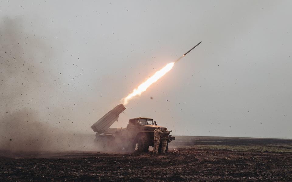 A rocket is fired into the air off the back of a vehicle in the middle of a field in Donetsk - Diego Herrera Carcedo/Anadolu Agency