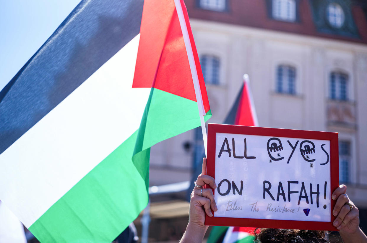 A Palestinian flag beside a sign that reads: All eyes on Rafah.