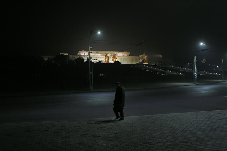 In this Tuesday Feb. 25, 2014 photo, a North Korean man walks on a street against the statues of the late leaders Kim Il Sung and Kim Jong Il at Mansu Hill in Pyongyang, North Korea. (AP Photo/Vincent Yu)