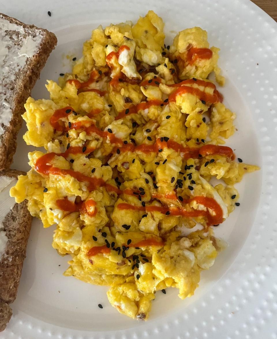 Cottage cheese scrambled eggs with Sriracha, Japanese BBQ sauce, and black sesame seeds.