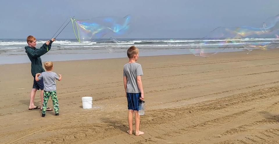 Making a giant bubble at Oceano Dunes State Vehicular Recreation Area on Friday, July 21, 2023, are, from left, Jackson Hauley, 14, Utah, Joseph Hauley, 5, Utah and Cash Livingston, 12, from Bakersfield. Visitors said they’re relieved the park will remain open to off-road riding.