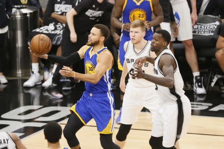 May 22, 2017; San Antonio, TX, USA; Golden State Warriors point guard Stephen Curry (30) drives to the basket past San Antonio Spurs small forward Davis Bertans (42) and Dewayne Dedmon (3) during the second half in game four of the Western conference finals of the NBA Playoffs at AT&T Center. Mandatory Credit: Soobum Im-USA TODAY Sports