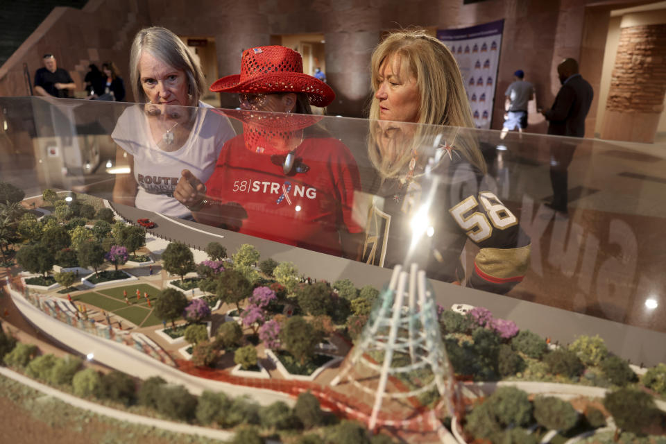 Route 91 Harvest festival shooting survivors, from left, Sue Nelson of Lake Havasu, Ariz., Sue Ann Cornwell of Las Vegas and Alicia Mierke of Henderson, Nevada, check out a model by 1 October Memorial finalist JCJ Architecture on display in the rotunda at the Clark County Government Center in Las Vegas, Monday, June 5, 2023. (K.M. Cannon/Las Vegas Review-Journal via AP)