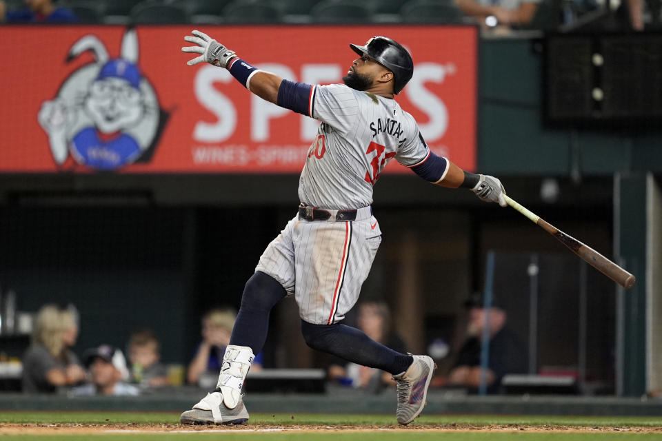 Minnesota Twins' Carlos Santana follows through on a sacrifice fly that scored Matt Wallner in the ninth inning of a baseball game against the Texas Rangers, Thursday, Aug. 15, 2024, in Arlington, Texas. (AP Photo/Tony Gutierrez)