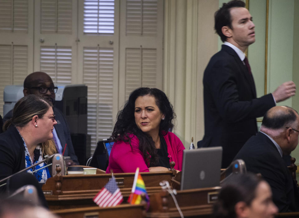 Assemblywoman Lorena Gonzalez, D-San Diego, talks with other assembly members on the Assembly floor at the Capitol in Sacramento, Calif., on Thursday, Feb. 27, 2020, as Assemblyman Kevin Kiley, R-Rocklin, walks past her. Gonzalez has proposed an amendment to Assembly Bill 5 — which requires many independent contractors to be re-classified as employees with benefits — that removes the submission cap but also mandates that freelancers cannot replace regular employees. (Daniel Kim/The Sacramento Bee via AP)