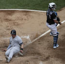 New York Yankees' Luke Voit, left, scores on a two-run single by Brett Gardner as Chicago White Sox catcher James McCann looks to the field during the third inning of a baseball game in Chicago, Sunday, June 16, 2019. (AP Photo/Nam Y. Huh)