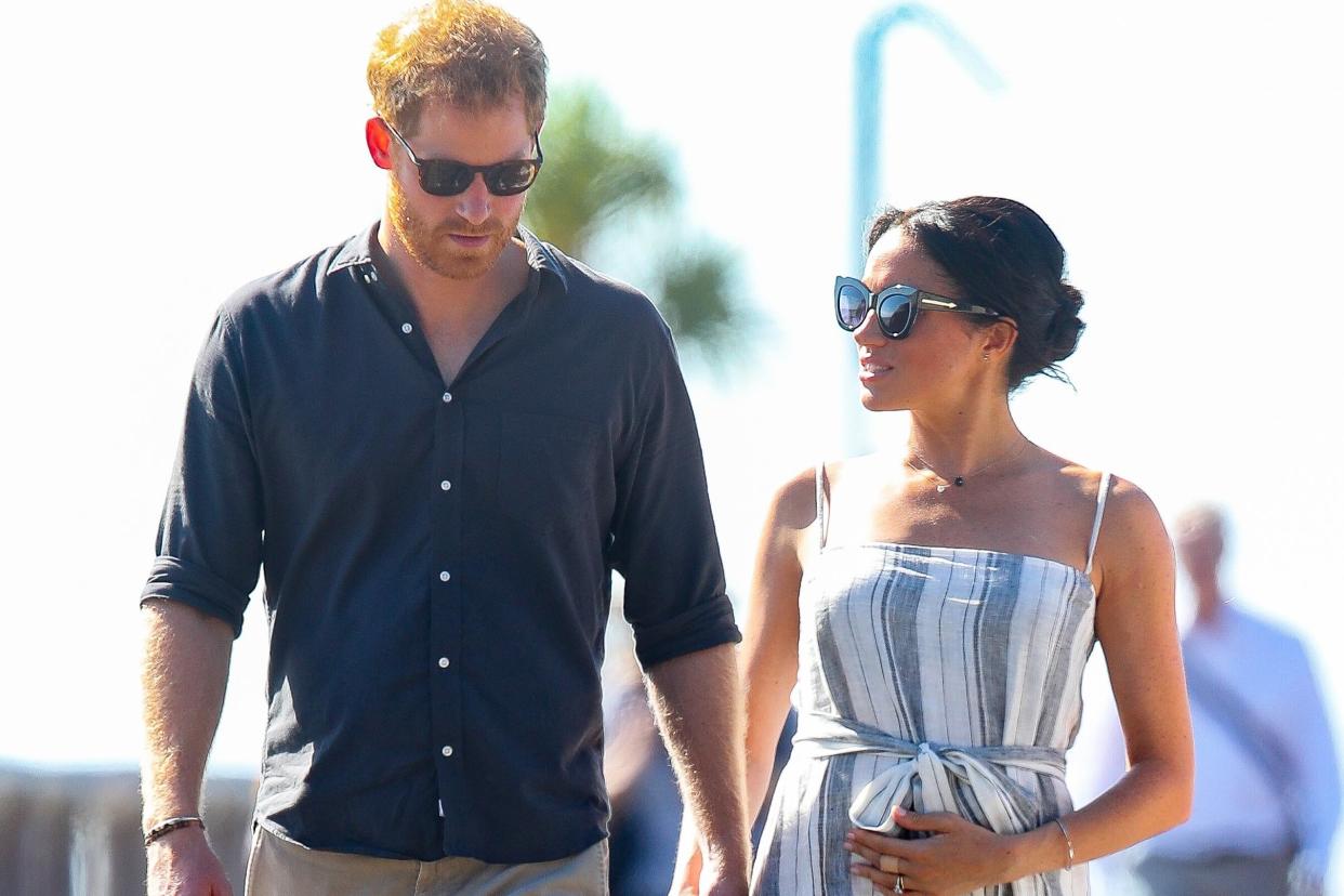 Meghan holds her baby bump she and Prince Harry walk along a wharf in Kingfisher bay: Getty Images