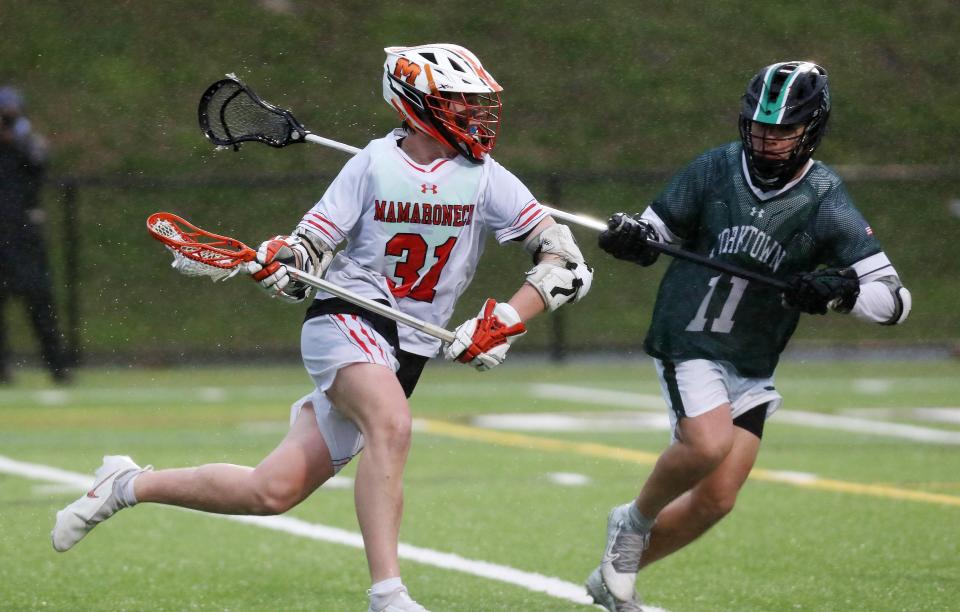 Mamaroneck's Alex Martin (31) drives to the goal in front of Yorktown's Giacomo Micciari (11) during boys lacrosse action at Mamaroneck High School April 7,  2022. Mamaroneck won the game 11-5.