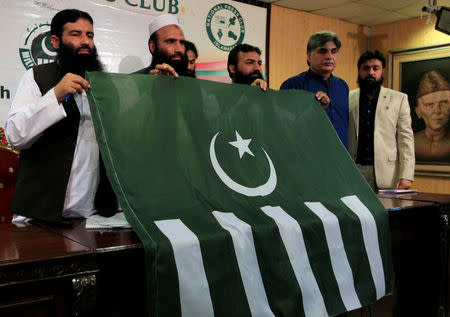 Saifullah Khalid (2nd L), President of Milli Muslim League (MML) political party, holds a party flag with others during a news conference in Islamabad, Pakistan August 7, 2017. REUTERS/Faisal Mahmood