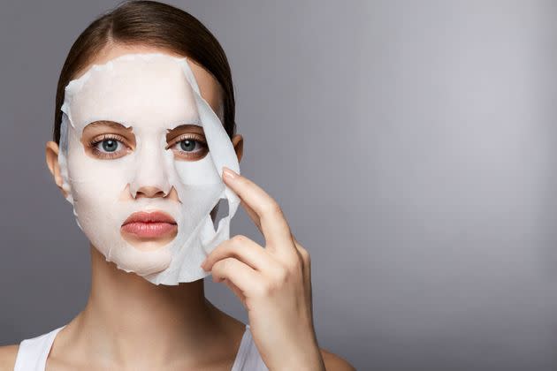 Sheet masks (as seen here) or masks that you slather on from a jar can help your skin with myriad benefits. (Photo: Ada Summer via Getty Images)