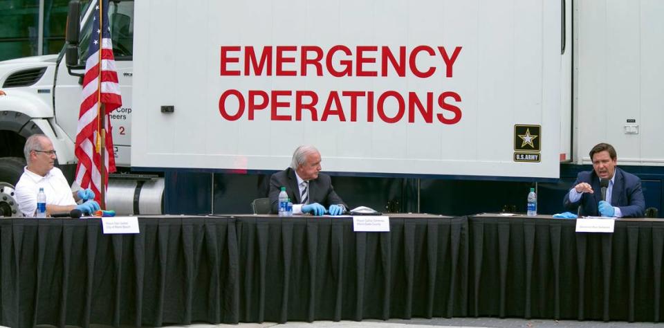 Miami Beach Mayor Dan Gelber (left), former Miami-Dade County Mayor Carlos Gimenez (center) and Florida Gov. Ron DeSantis (right), at the Miami Beach Convention Center on April 8, 2020, discuss the Army Corps’ building of a coronavirus field hospital inside the facility.