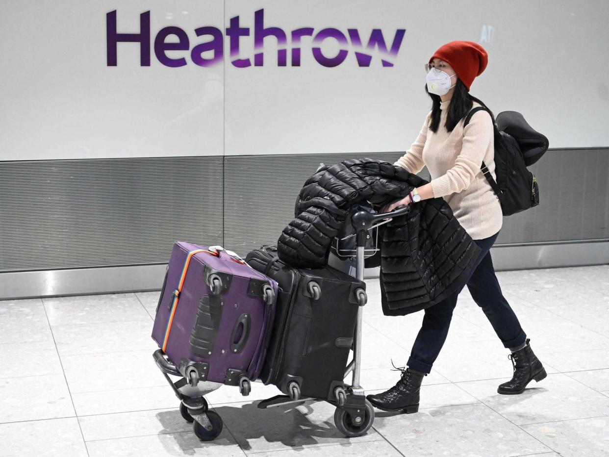 A passenger wearing a face mask arrives at Heathrow Airport on Wednesday, hours before British Airways suspended all flights from China: AFP via Getty Images