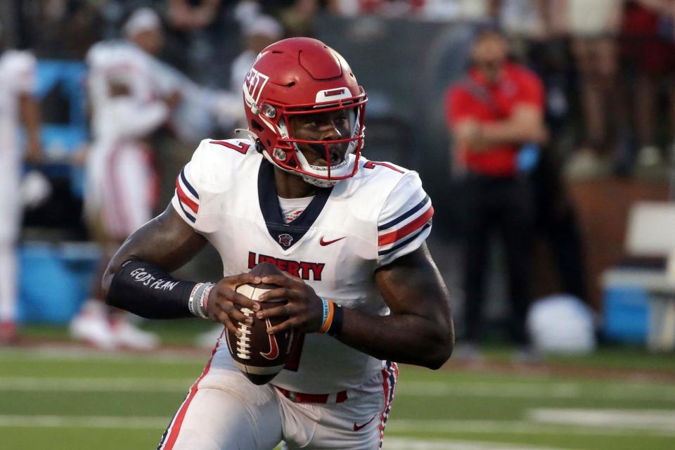 FILE - Liberty quarterback Malik Willis (7) carries the ball against Troy during the first half of an NCAA football game in Troy, Ala., in this Saturday, Sept. 11, 2021, file photo. The Flames, behind former Auburn quarterback Malik Willis, have beaten Campbell (48-7) and Old Dominion (45-17) at home and edged Troy (21-13) on the road. They play at Syracuse on Friday night, Sept. 24. (AP Photo/Butch Dill, File)