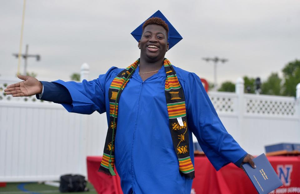 Natick High School graduate D'Anthony Boutwell smiles with his diploma during Natick High School Graduation at Memorial Field, June 3, 2022.