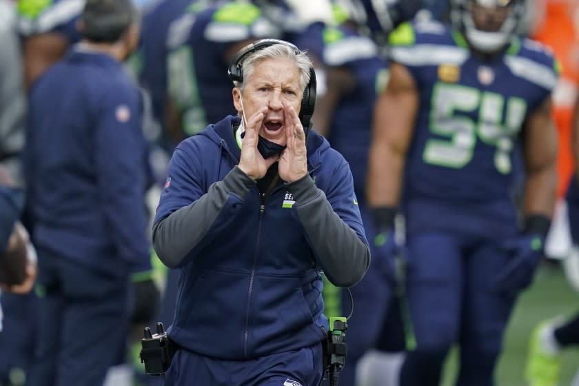 Seattle Seahawks head coach Pete Carroll calls to his team during the first half of an NFL.