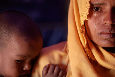 Roshid Jan, a Rohingya refugee who said she is not sure about her age, cries holding her son Muhammad Gyab at their shelter at the camp for widows and orphans inside the Balukhali camp near Cox's Bazar, Bangladesh, December 5, 2017. REUTERS/Damir Sagolj