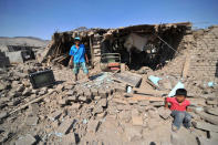 A man and a child stand at debris of a building after a strong magnitude 7.1 earthquake struck the coast of southern Peru, in Acari, Arequipa , Peru, January 14, 2018. REUTERS/Diego Ramos