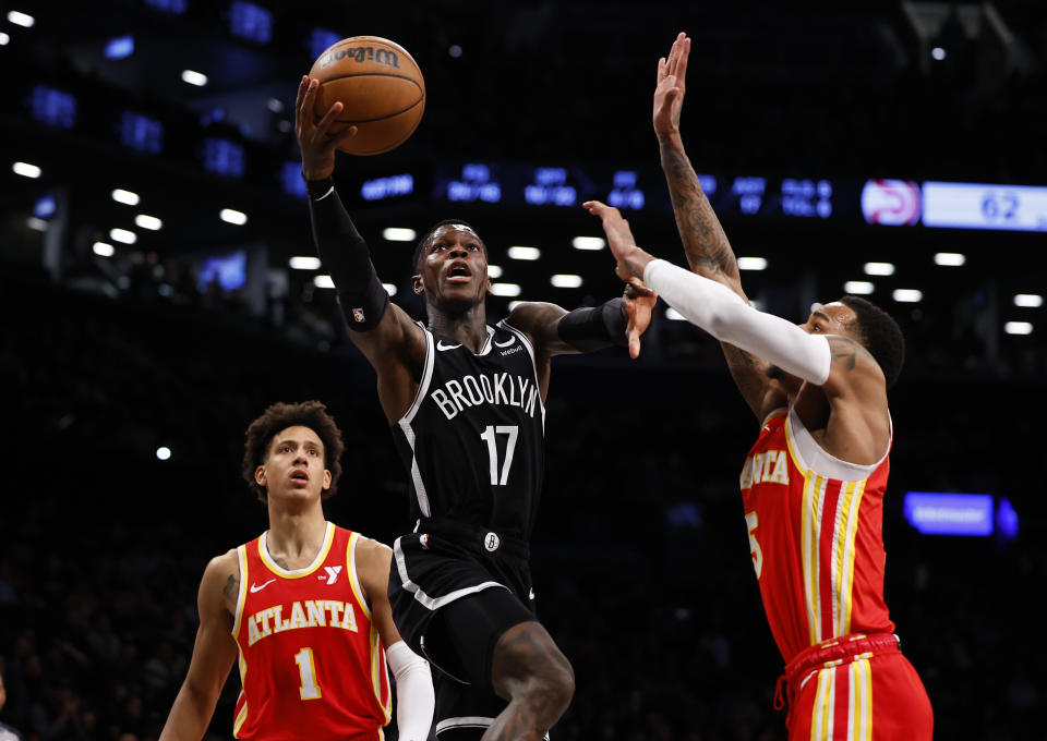 Brooklyn Nets guard Dennis Schroder (17) drives to the basket against Atlanta Hawks forward Jalen Johnson (1) and Atlanta Hawks guard Dejounte Murray during the first half of an NBA basketball game, Saturday, March 2, 2024, in New York. (AP Photo/Noah K. Murray)