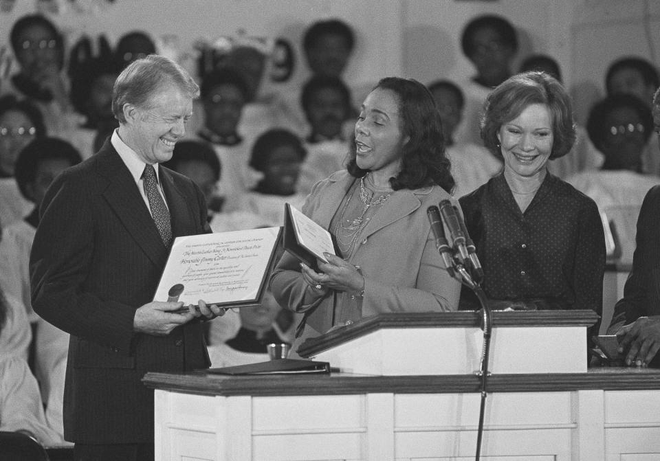FILE - Coretta Scott King, center, widow of Martin Luther King Jr., presents the Martin Luther King Jr. Non-Violent Peace to President Jimmy Carter at the Ebenezer Baptist Church in Atlanta on Jan. 14, 1979. First lady Rosalyn Carter stands with them at the podium. (AP Photo/Jim Wells, File)