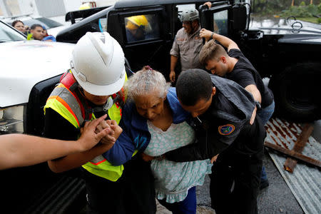 Rescue workers help a woman to get into the Emergency Operation Centre after the area was hit by Hurricane Maria in Guayama, Puerto Rico September 20, 2017. REUTERS/Carlos Garcia Rawlins