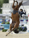 Hwang Woojin, of South Korea, and his horse Shearwater Oscar, fall down after the horse bucked after the starting bell sounded to start their run in the equestrian show jumping stage of the men's modern pentathlon at the 2012 Summer Olympics, Saturday, Aug. 11, 2012, in London.(AP Photo/Markus Schreiber)